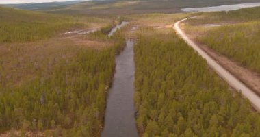 Luttojoki Nehri ve Rajajoosepintie yolunun bulutlu bahar havasında hava manzarası, Inari, Lapland, Finlandiya.