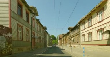 Tallinn, Estonya - 6.26.2023: Tallinn 'deki Technika yolunda yol boyunca eski ahşap binalarla giden araçtan POV manzarası.