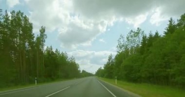 10. karayolu, Estonya - 6.26.2023: Bulutlu yaz havasında kırsal alanda otoyolda araba sürerken POV manzarası.