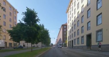 Helsinki, Finlandiya - 6.26.2023: Helsinki 'de yol boyunca binalarla birlikte araç kullanırken POV manzarası.