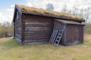 Baharda Bjorklund çiftlik müzesindeki eski ahşap bina, gökyüzünde bulutlar, Svanvik, Norveç.