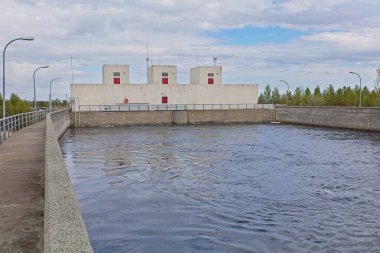 Pasvik Nehri üzerindeki Skogfoss santrali. Norveç 'in bulutlu bahar havasında..