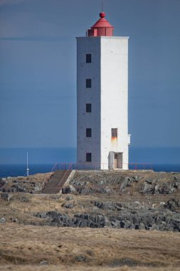 Kjolnes Deniz Feneri 'nin yaz mevsiminde mavi gökyüzüne karşı manzarası, Berlevag, Norveç.