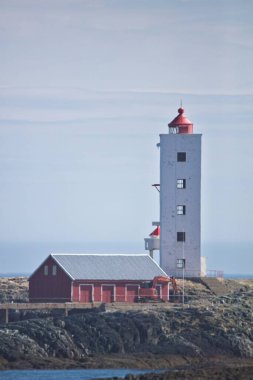 Kjolnes Deniz Feneri 'nin yaz mevsiminde mavi gökyüzüne karşı manzarası, Berlevag, Norveç.