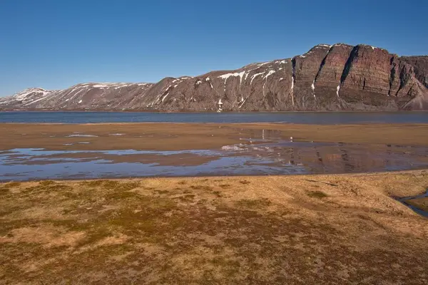 Lavonjarg ve Giemas dağlarındaki kumlu sahilin manzarası açık yaz havasında, Varanger Yarımadası, Norveç.