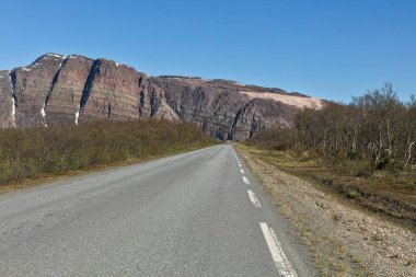 View of Austertanaveien road 890 in clear summer weather, Varanger Peninsula, Norway. clipart