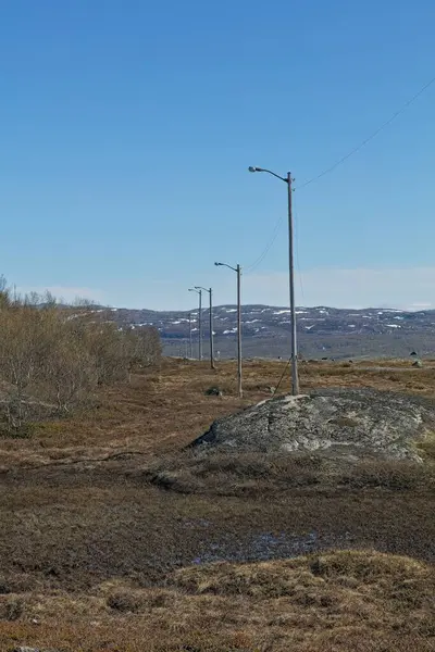Yaz mevsiminde Skytterhusfjellet dağında kayak yapmak için gece direkleri, Kirkenes, Norveç.
