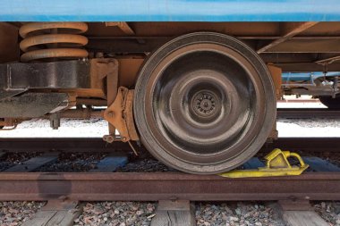 Sarı butonlu bir tren vagonunun tekerlek ve frenine yakın..