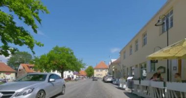 Kuressaare, Saaremaa, Estonya - 28 Haziran 2023: Yazın asfalt bir yolda Kuressaare şehir merkezinde araba sürerken POV manzarası.