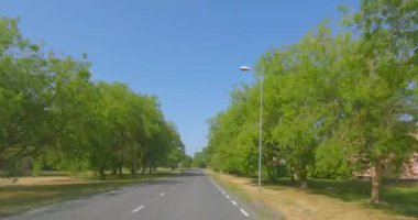 Kihelkonna, Saaremaa, Estonia - June 28.2023 : POV view from car driving to Kihelkonna village on a asphalt road in summer.