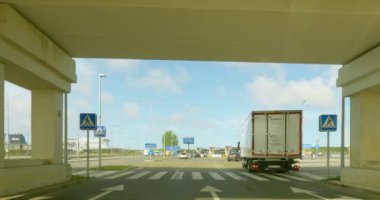 Klaipeda, Lithuania - July 13.2023 : POV view from car driving to Klaipeda to Smiltyne ferry port in cloudy summer weather.