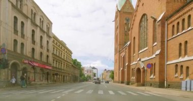 Riga, Latvia - July 9.2023 : POV view from car driving in Riga city on a asphalt road in summer with clouds in the sky.