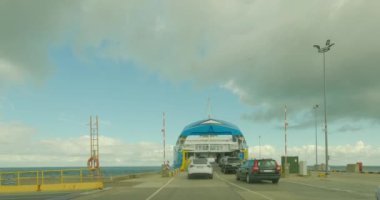 Kuivastu, Muhu, Estonia - July 8.2023: POV view from car driving  into car ferry at Kuivastu port in cloudy summer weather.