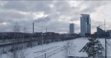 Donmuş deniz manzarası Kalasatama ve Verkkosaari marinası gökdelen binaları ve Itavayla hareketli arabalar ve metro ile bulutlu kış günü, Helsinki, Finlandiya.