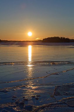 Kışın gün batımında deniz manzarası. Donmuş deniz, Kallahdenniemi, Helsinki, Finlandiya.