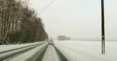 Bulutlu kış havasında Viikintie yolunda araba sürerken çekilen POV manzarası ve yerde kar, Helsinki, Finlandiya.