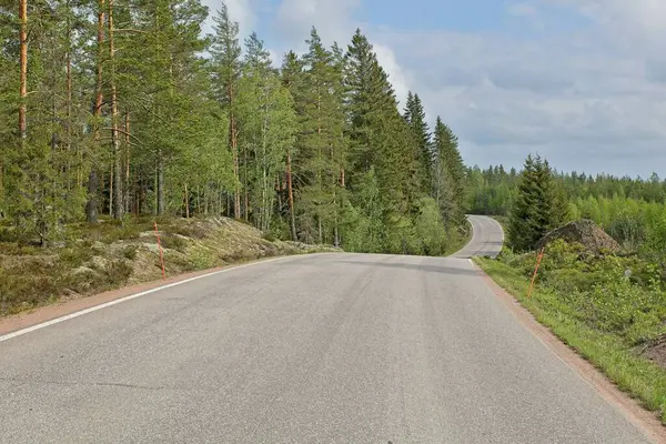 Asfalt Taavetintie yolu ilkbaharda gökyüzünde bulutlar, Miehikkala, Finlandiya.