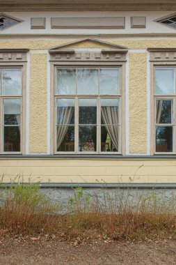 Baharda pencereye yakın sarı köşk duvarı.