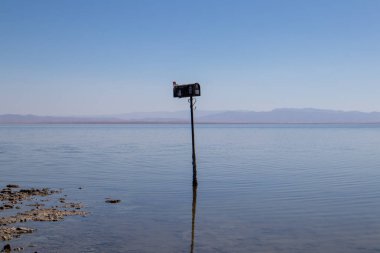 A lonely mailbox stands in the water of the Salton Sea in Southern California. At the abandoned Bombay Beach. High quality photo clipart