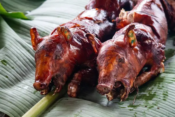 Filipinler 'de Cebu' nun dışında muz yapraklı iki Spit-Roasted Lechon. Yüksek kalite fotoğraf