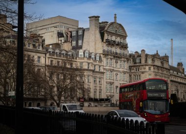 Londra 'da Wellington Meydanı Dükü' nün 2023 baharında inşa ettiği eski bina. Görüntünün alt kısmı park çitleri tarafından çerçevelenmiş ve ortada ikonik kırmızı bir Londra otobüsü var..