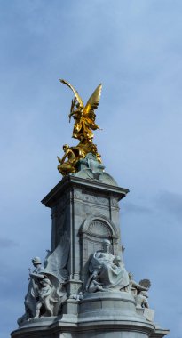 2023 'te Londra' daki Buckingham Sarayı 'nın önündeki Victoria Anıtı' nda altın bir heykel. Heykel mermer bir sütunun üzerinde. Çivit mavisi gökyüzü beyaz ve altın heykel ile güzel bir kontrast oluşturuyor..