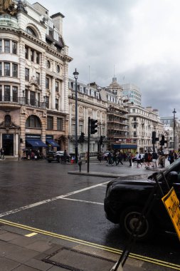Mart ayında Londra 'da Piccadilly ve St. James caddelerinin köşesindeki bina. Gökyüzü bulutlu ve sokaklar yağmurdan ıslanmış..