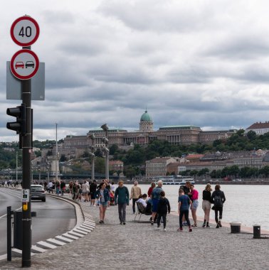 Macaristan 'ın Budapeşte kentinde Tuna kıyısında yayalarla dolu bir yol.. 