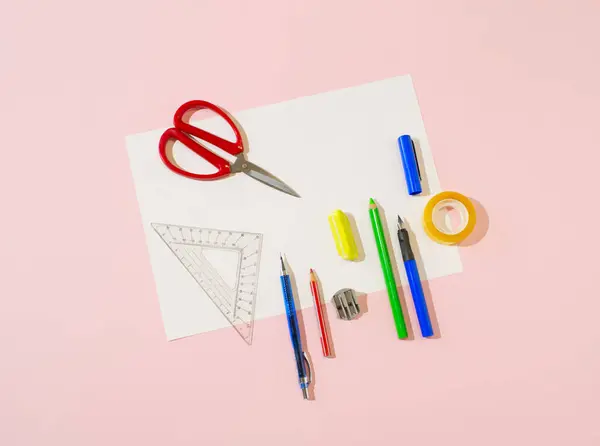 A minimal composition made of school or office supplies on a pink background. Creative school layout. Minimal concept. Pastel color palette. Copy space. Flat lay