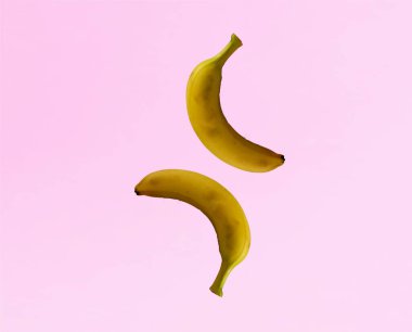 Açık pembe arka planda izole edilmiş muzlar. Uzayı kopyala Düz yatıyordu. Minimum meyve konsepti. Yaratıcı desen. 