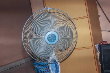 Bir odada bir fan duruyor.