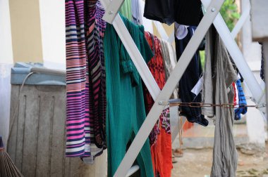 Giysileri güneşte kurutulan bir evden alınan çamaşır ipleri.