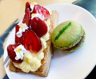 Peynirle dolu bir dilim pasta ve naneli kurabiye.