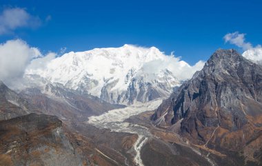 Ünlü Kanchenjunga Turu sırasında Güney Kanchenjunga 'nın güzelliğini yansıtan enfes bir stok görüntüsü. Yalung Buzulu yamaçlarından görkemli bir şekilde yükselirken, karla kaplı tepe açık bir gökyüzü zeminine hakim oluyor.. 