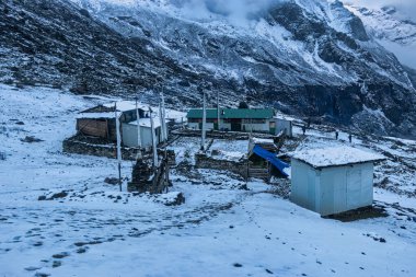 Dağdaki Sherpa evini kar kaplıyor. Bu güzel görüntü, Makalu 'nun Nepal' deki ana kamp yürüyüşü sırasında çekildi..