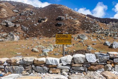 Nepal 'deki Makalu Trek' in engebeli patikasında yer alan Makalu Ana Kampını gösteren Sersong tabelasının canlı bir görüntüsü..