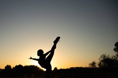 İspanya 'nın Barselona yakınlarındaki İspanyol köyü El Papiol' de yaz yürüyüşü yapan genç ve güzel bir kadının silueti.  