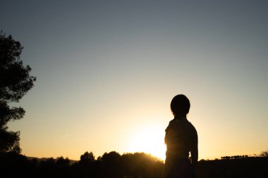 İspanya 'nın Barselona yakınlarındaki İspanyol köyü El Papiol' de yaz yürüyüşü yapan genç ve güzel bir kadının silueti.  