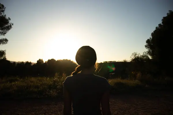 stock image Silhouette of a young beautiful female in nature on a summer walk during golden hour in the spanish village El Papiol, near Barcelona, Spain  
