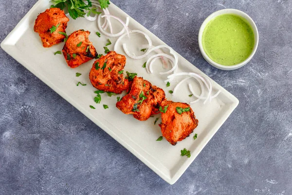 Hint tavuğu aperatifi, Tikka tavuğu soğan ve Cilantro üstten aşağıya fotoğraf ile süslenmiş.