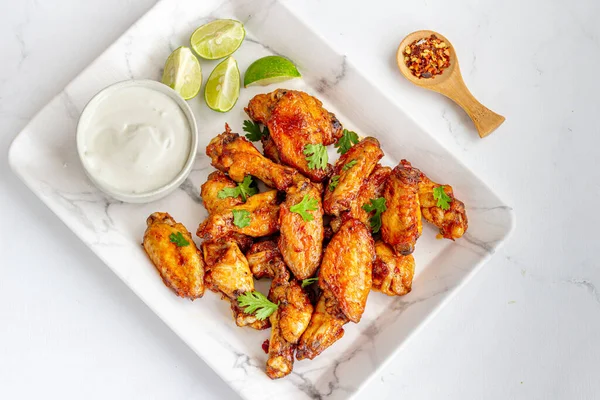 Soslu fırında tavuk kanadı, limon, Cilantro ve Chili Flakes Beyaz Arkaplan 'da tepeden tırnağa fotoğraf
