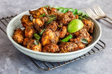 Baharatlı Güney Hindistan tavuğu aperatifi Limon ve Curry Leaves Yakın plan Hint yemeği fotoğraflarıyla süslenmiş.