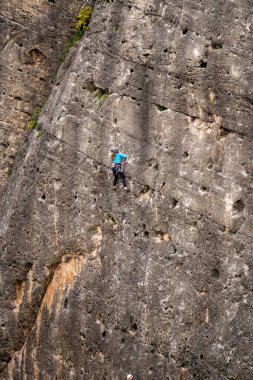 Genç adam kaya duvarına tırmanıyor..