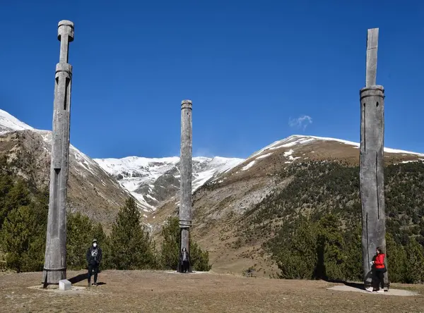 Bir dağın önünde duran bir grup insan.
