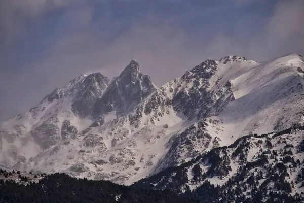 Arkasında karla kaplı dağlar olan bir dağ sırası.