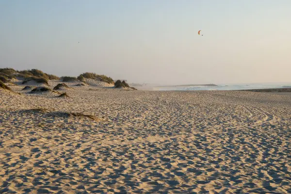 Kumsalda kum tepeleri ve uçurtması var.