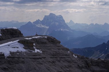 Vadi manzaralı bir dağın tepesinde duran bir insan.