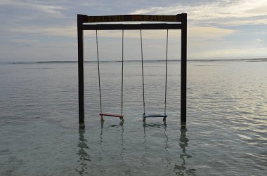 Arka planda deniz varken sahilde sallan.