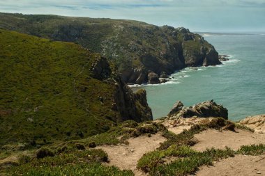 Kayalık deniz kıyıları ve dağları olan güzel bir manzara.