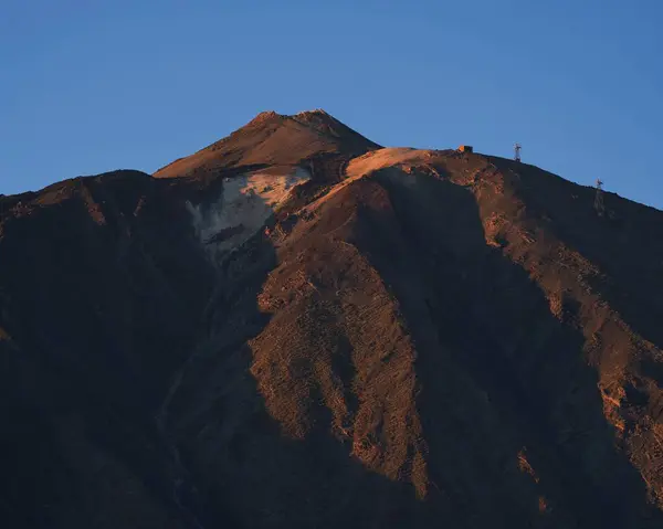 Güzel gün batımına sahip bir dağın dikey görüntüsü.